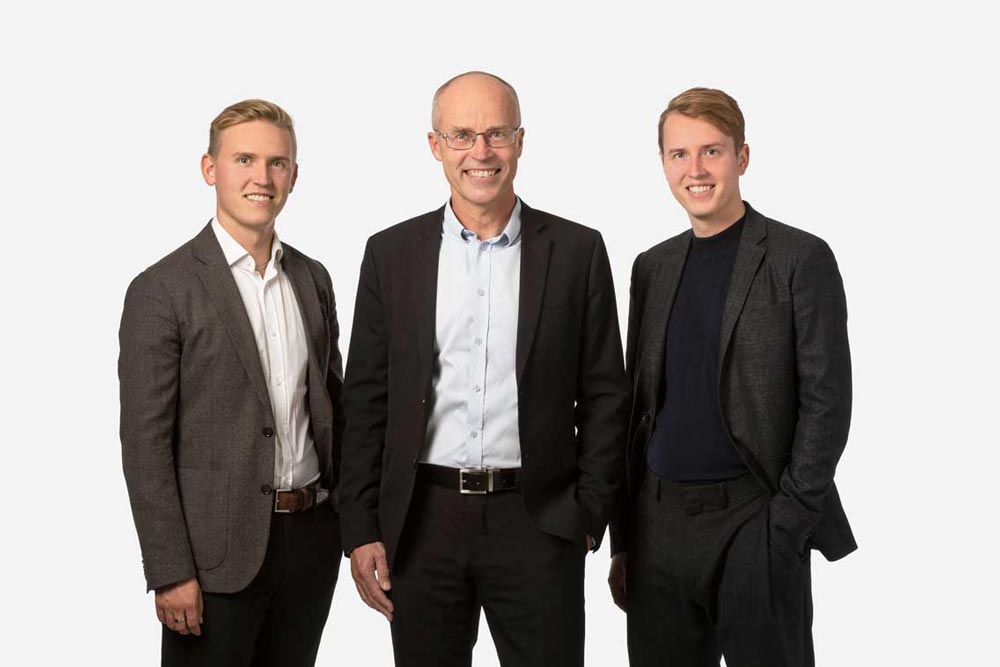 Tre medarbetare på Forsbloms fastighetsutveckling ler